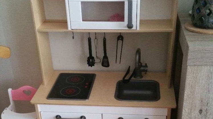 Houten speelkeukentje en speelgoed zat